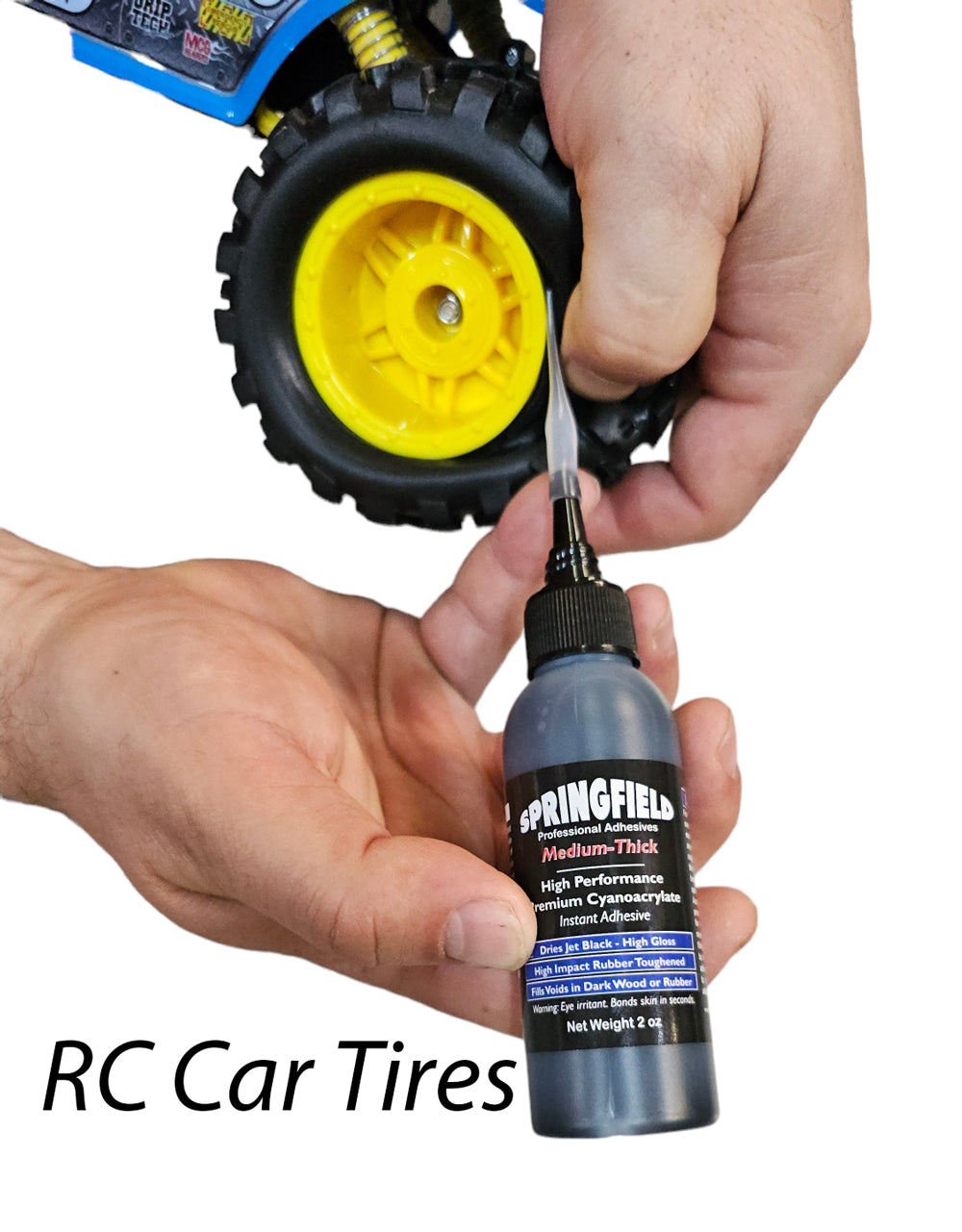 Person applying Springfield lubricant to RC car tires with a white background